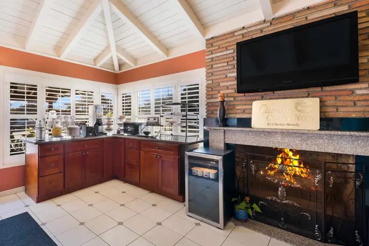 Breakfast room with a fireplace in a brick surround, a flat-screen TV and a wood breakfast counter